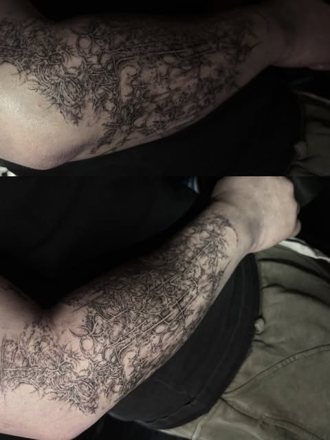 surreal black and gray tattoos across both arms