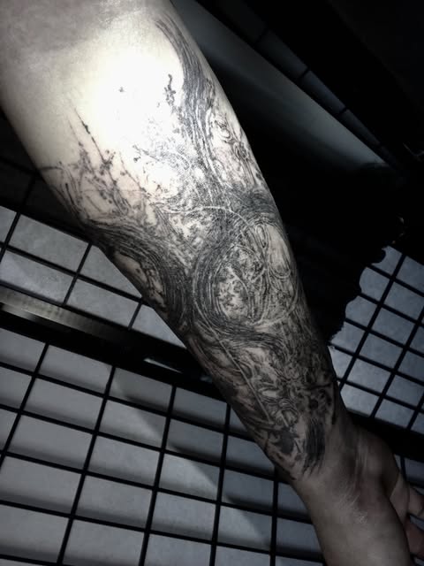 dark illustrative black and gray forearm tattoo