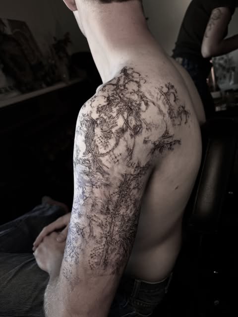 black and gray shoulder and upper-arm tattoo