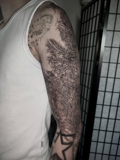 organic black and gray upper-arm tattoo